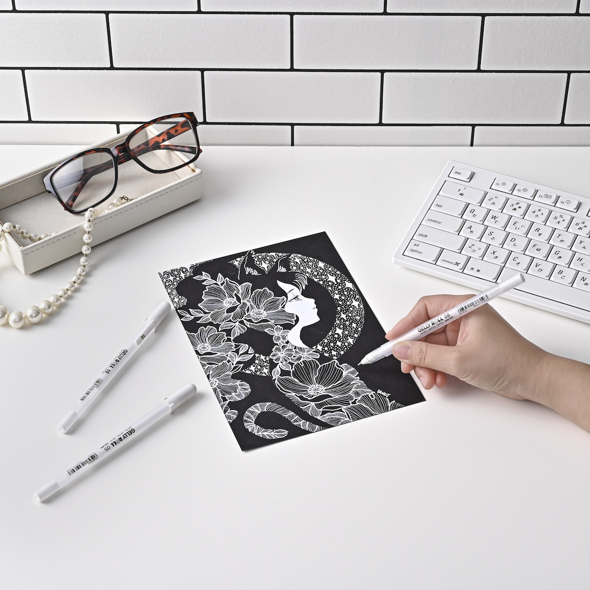 白ペンでイラストを描く手元の撮影