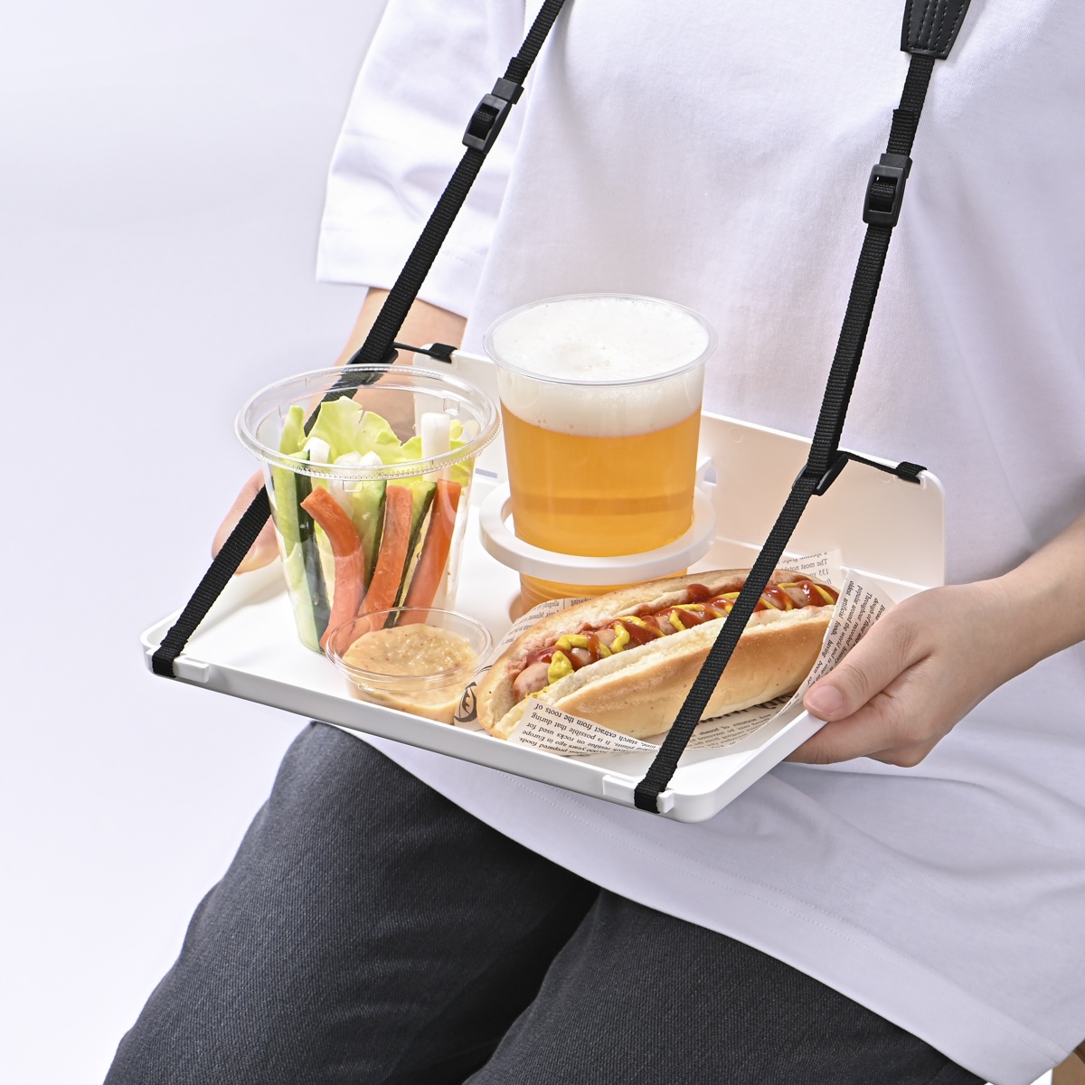 首掛けトレイでフードとドリンクを持つシーン