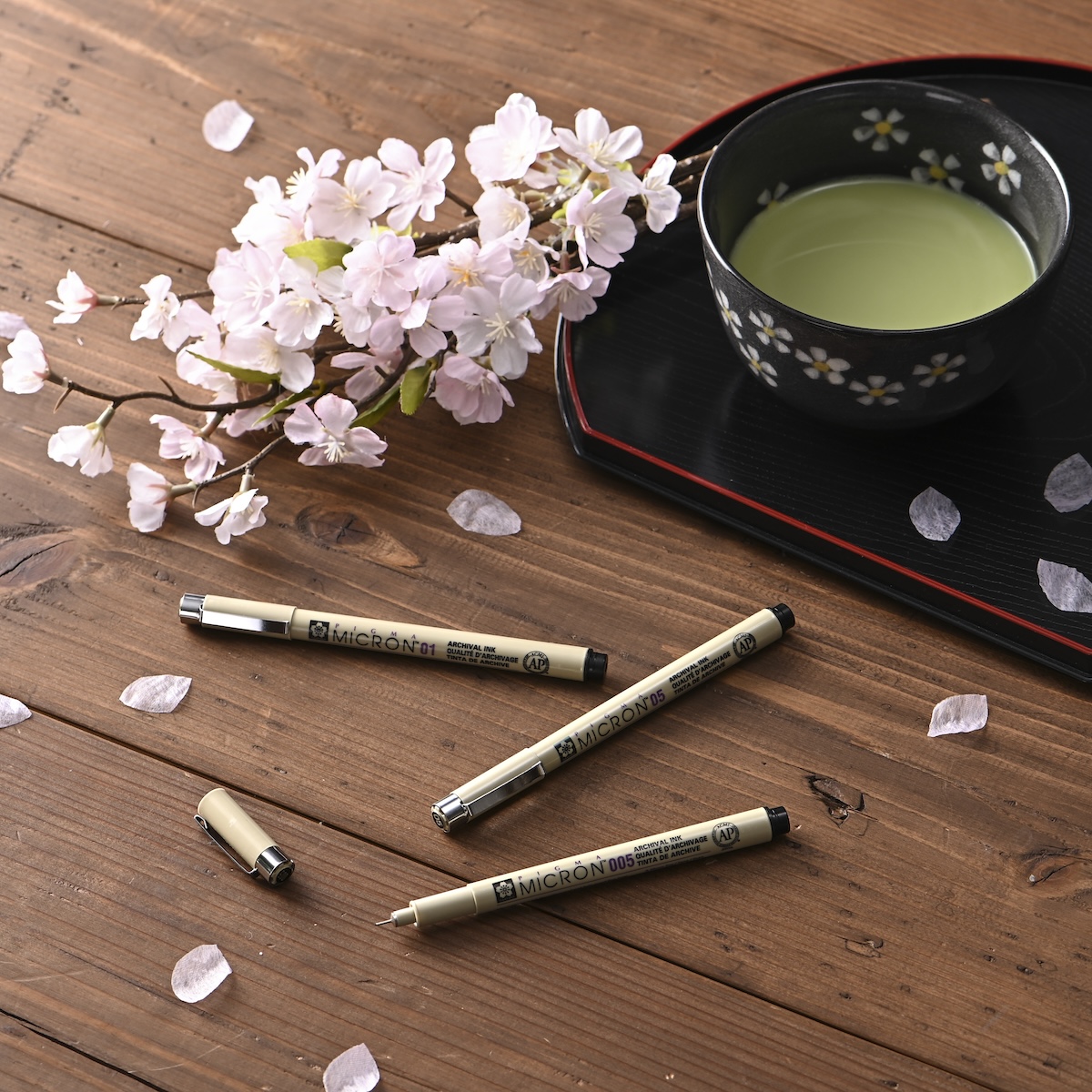 シチュエーションの撮影実績：MICRONのペンを桜の枝や花びら、茶器と組み合わせ、メーカー名に合わせた和の雰囲気で撮影しました。