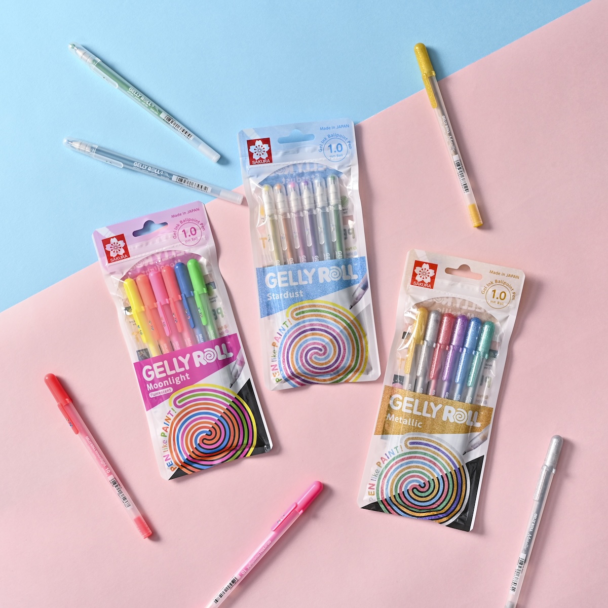 シチュエーションの撮影実績：ゲルインクペン「GELLY ROLL」のMoonlight、Stardust、Metallicシリーズを、青とピンクの2色の背景紙に分けて並べ、パッケージのデザインパターンとポ…