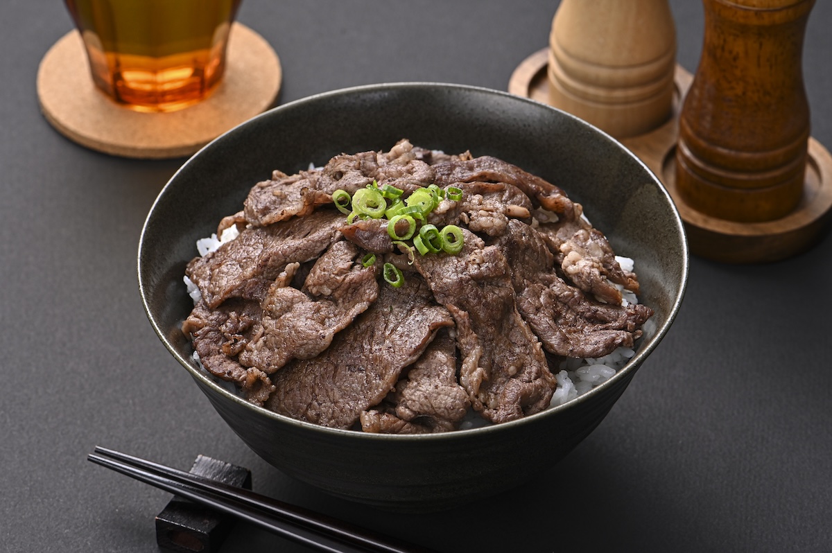 シチュエーションの撮影実績：牛肉を大きめの丼に盛った牛丼として撮影し、ご飯を高めに盛り付けた上に肉を並べることで、量感と高級感を表現しました。