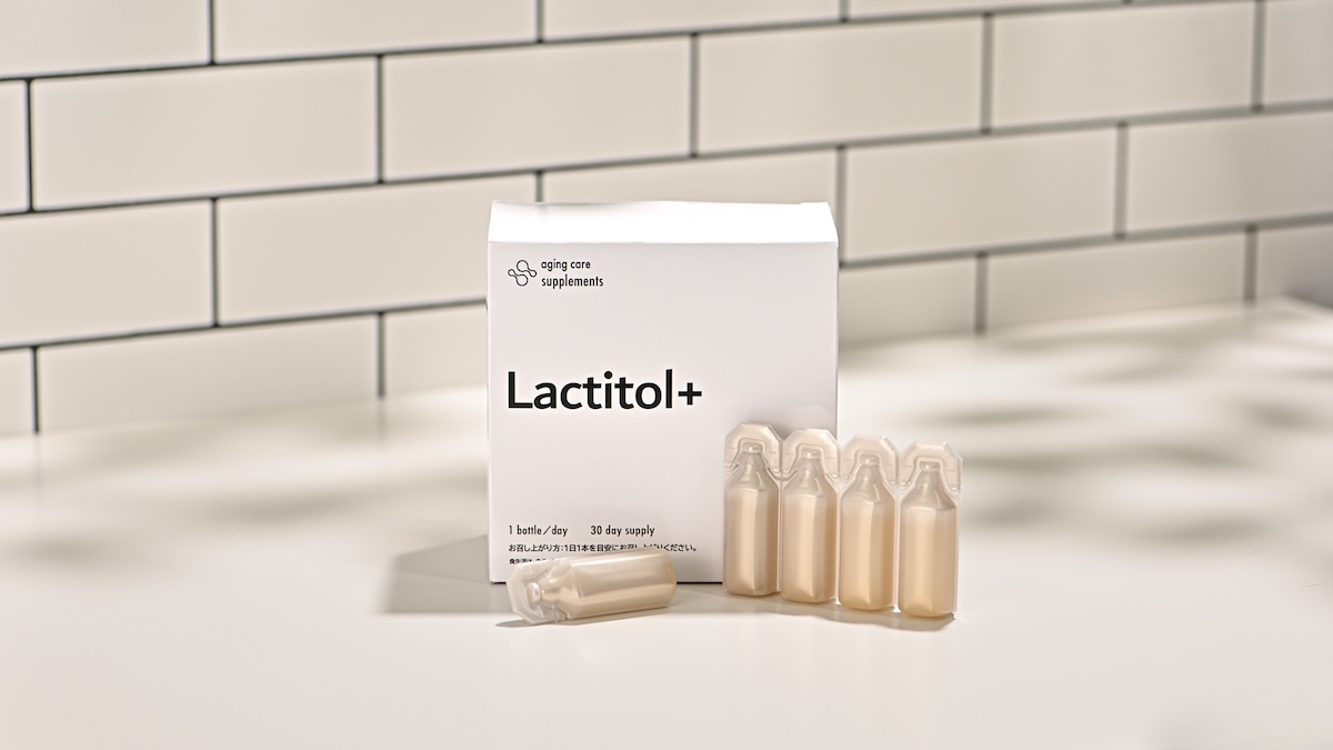 シチュエーションの撮影実績：Lactitol+のエージングケアサプリメントを、外箱と一日分の小分けボトルが見比べやすいよう、白いカウンター上で撮影しました。