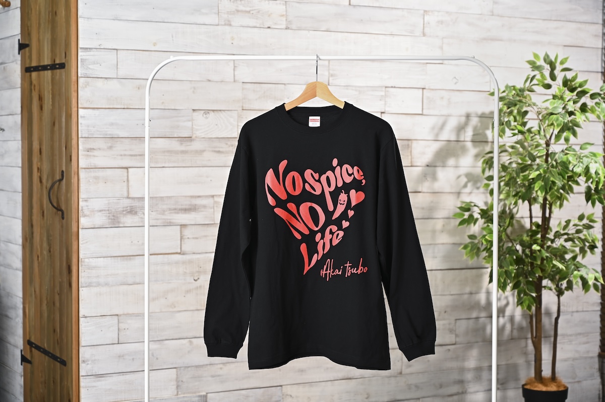 シチュエーションの撮影実績：黒い長袖Tシャツを木製ハンガーに掛け、胸元の「No spice, No life」のグラフィックと商品の全体シルエットが正面から見えるように撮影しました。