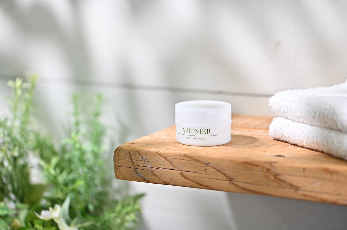 シチュエーションの撮影実績：APIONIERのtotal skin creamを木の台の中央に置き、白い容器と正面のロゴが見やすいように撮影しました。