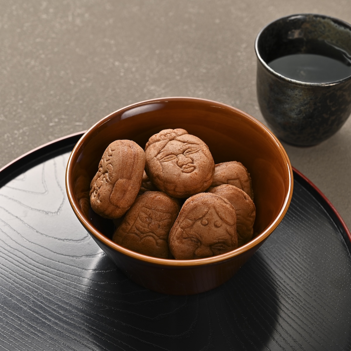 シチュエーションの撮影実績：表情の異なる焼き菓子を朱色の器に盛り、型押し模様、焼き色、丸みが見えるように撮影しました。